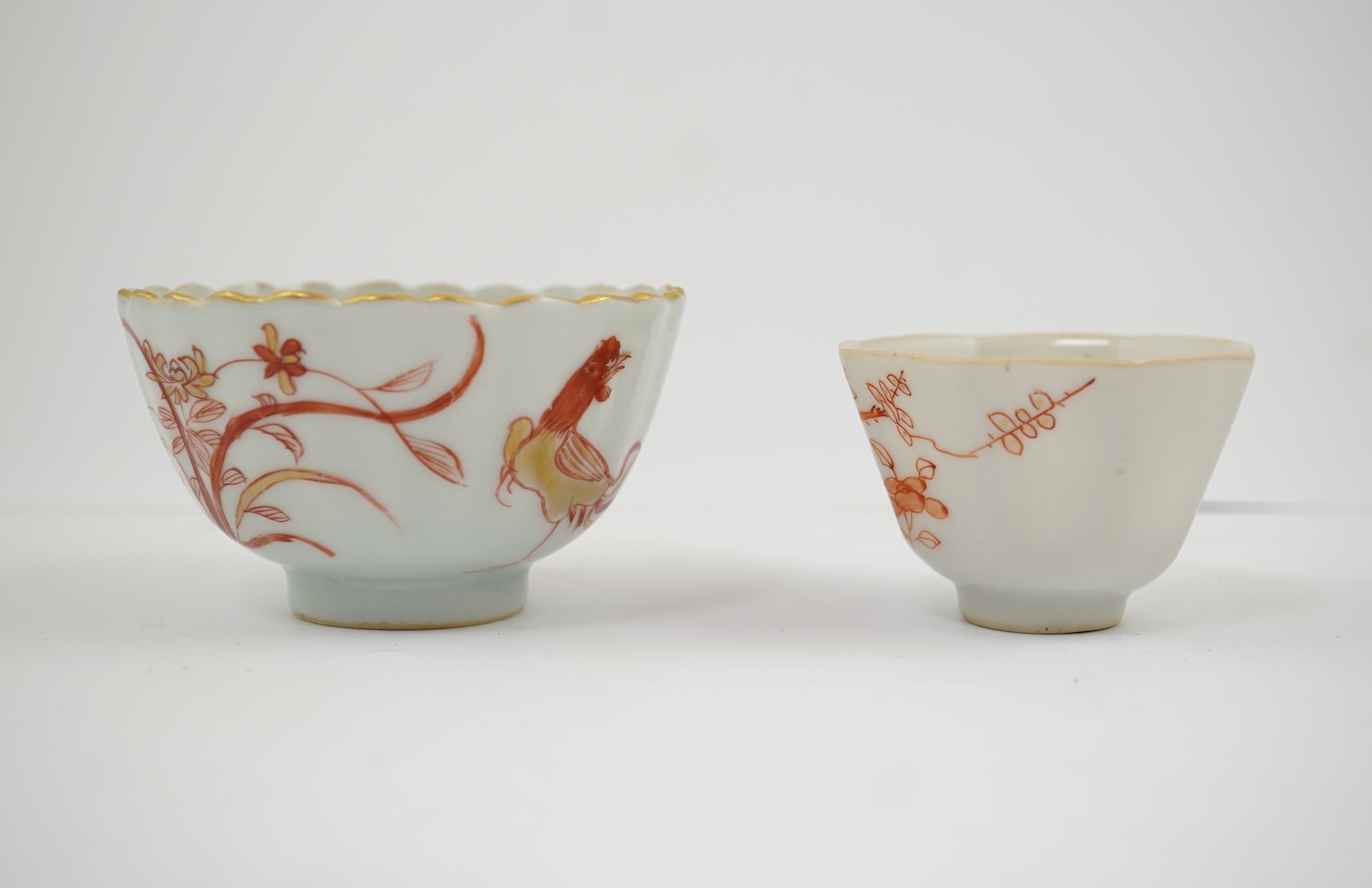 A Chinese rouge de fer tea bowl and saucer and a similar cup, Qianlong period